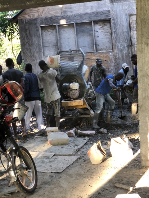 Chaos reigned around the cement mixer as workers brought buckets of sand, gravel and water to mix with cement and others scooped up the mixture in buckets to send up the ladder.