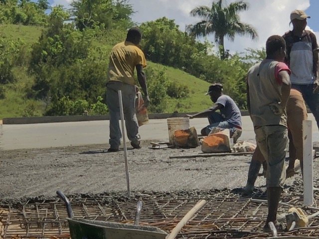 Spreading the final layer of cement powder to smooth and seal the surface.