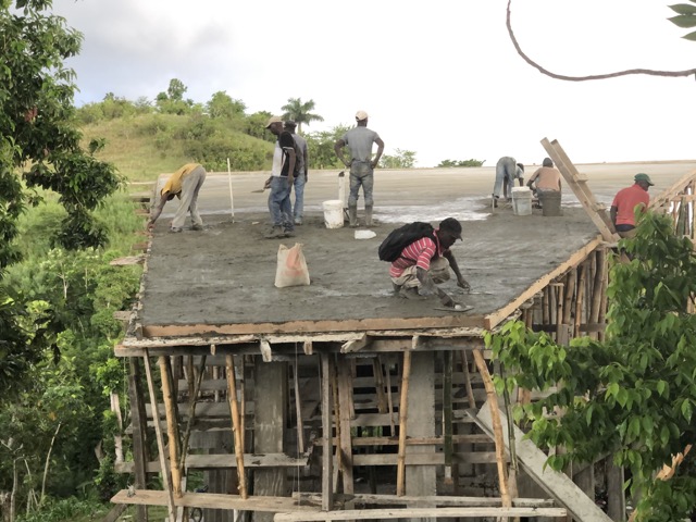 The masons work on the final, smooth coat on the roof shortly before raindrops began to fall.