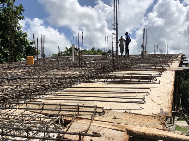 Iron bars and electrical pipes being placed on the roof.