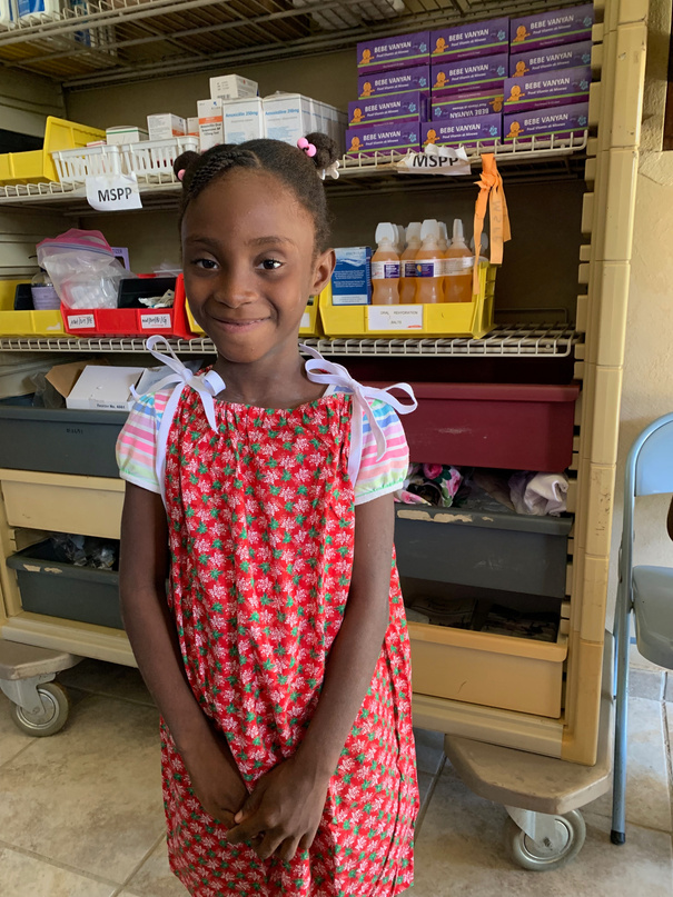 Little girl receiving a new Christmas dress from the nurses in our pharmacy.