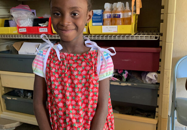 Little girl receiving a new Christmas dress from the nurses in our pharmacy.