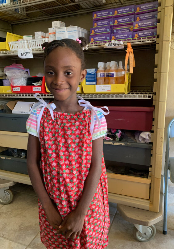 Little girl receiving a new Christmas dress from the nurses in our pharmacy.